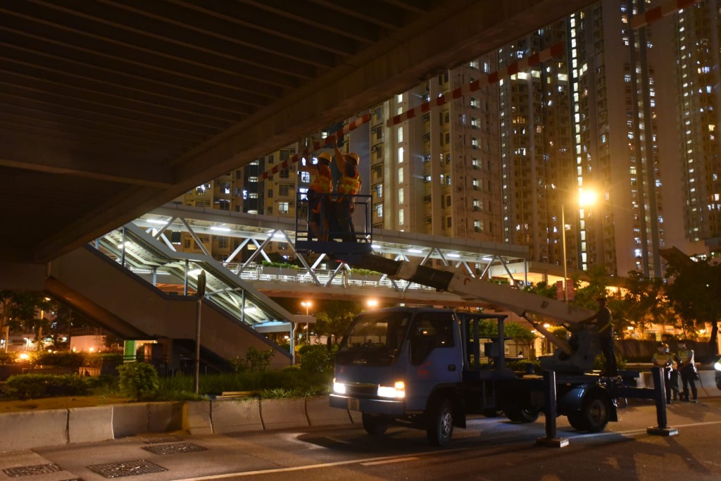 觀塘道近九龍灣站的天橋標示杆鬆脫，工人到場維修。