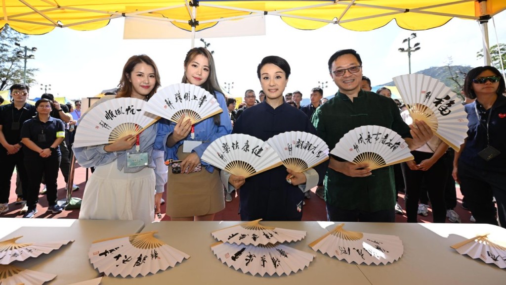 粵劇名伶蓋鳴暉（右二）、懲教署署長黃國興（右一）及香港小姐2023參觀攤位。