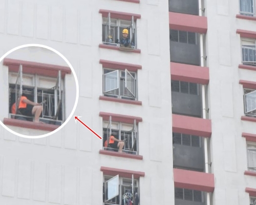 男子手持菜刀危坐高層單位外的窗邊。林思明攝