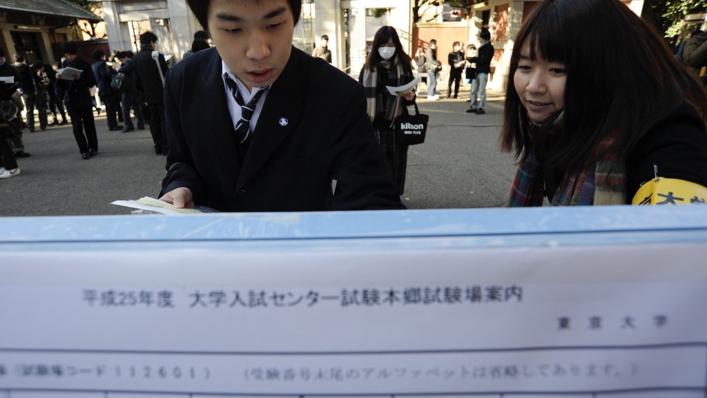 日本學生考大學，在試前查閱考場位置。 新華社資料圖