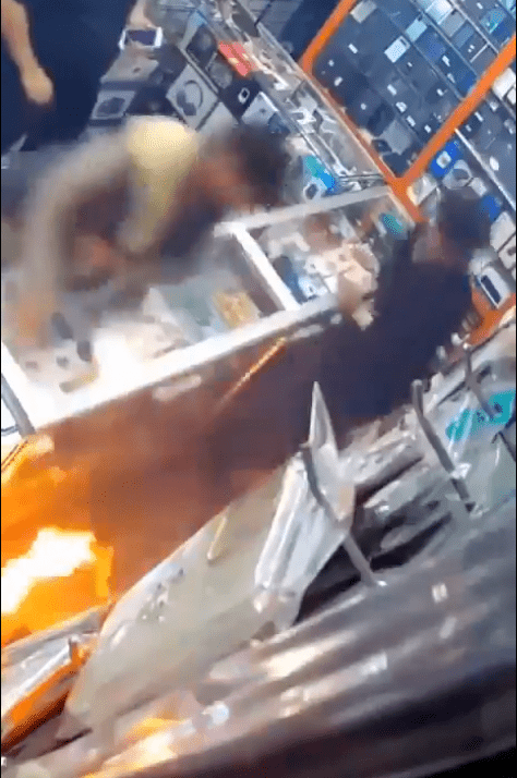 男童受驚後立即把電池拋開，店主亦顯得手足無措，急忙嘗試撲救。