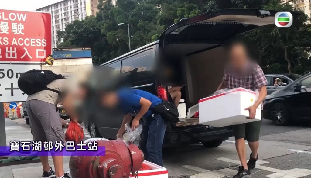 有客貨車在寶石湖邨外巴士站等候,見水貨客一到即派貨。(無綫電視畫面截圖)