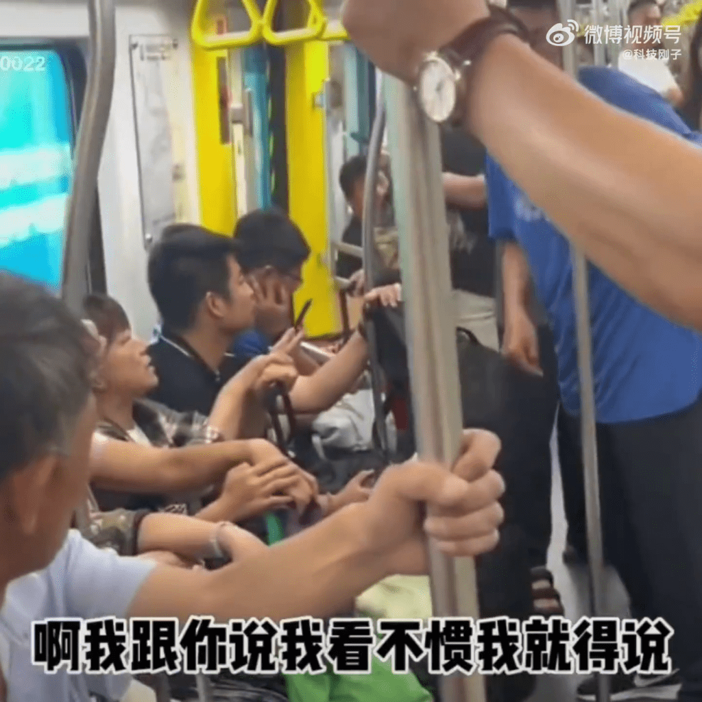 蓝衫的大爷因护妻占位，与女乘客起争执。
