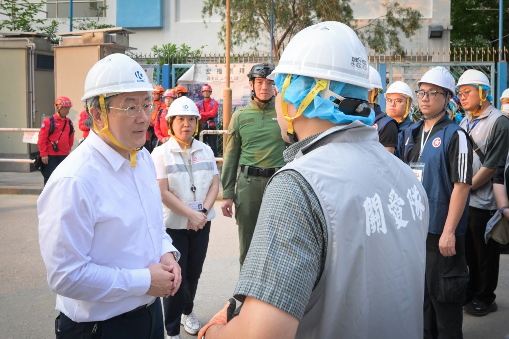 卓永兴（左）感谢地区服务及关爱队伍队员配合，支援上楼居民。