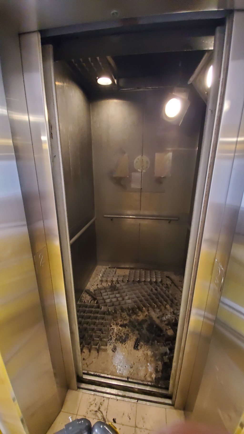 被縱火電梯嚴重熏黑，有配件跌在地面。蔡楚輝攝