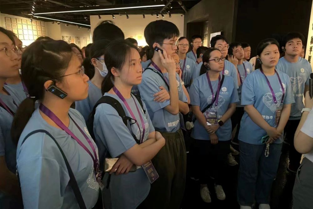 團員在侵華日軍南京大屠殺遇難同胞紀念館用心聆聽講解。