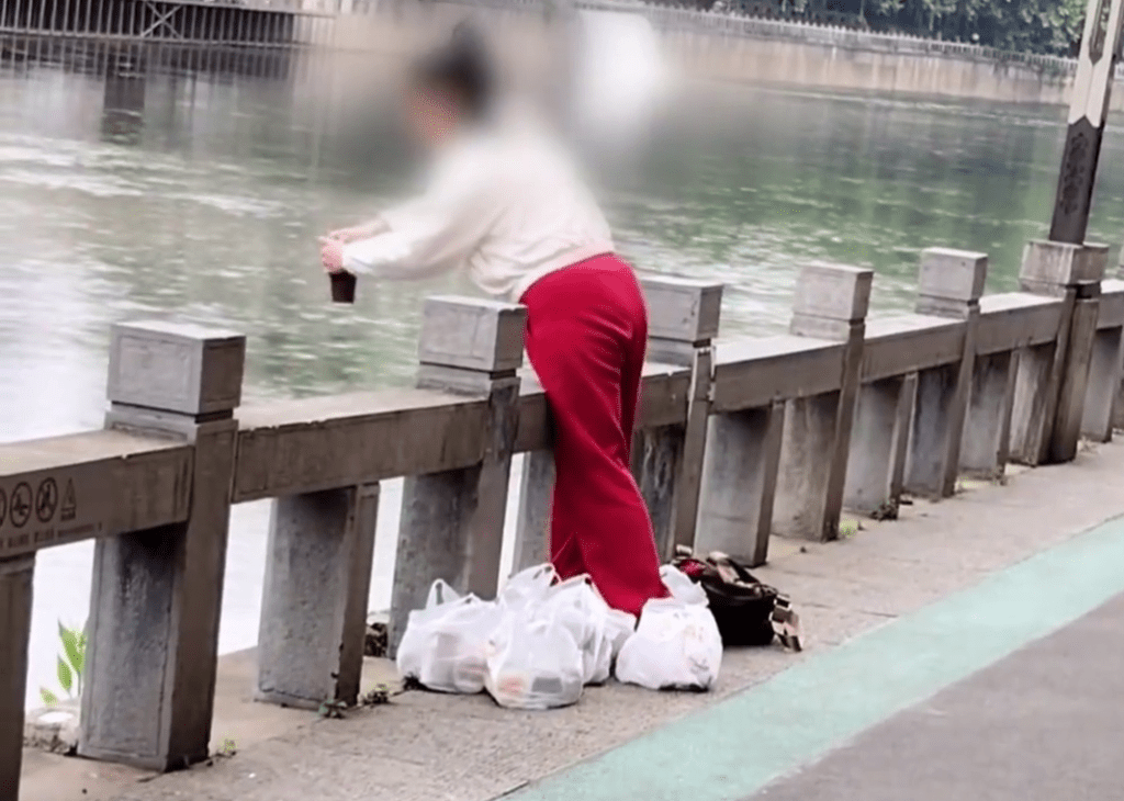 貴州女子在河邊將一杯一杯的奶茶「放生」。