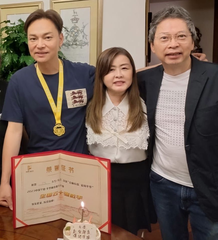 方俊展示打入决赛证书及奖牌，跟环星唱片老板张国林及其女友分享。