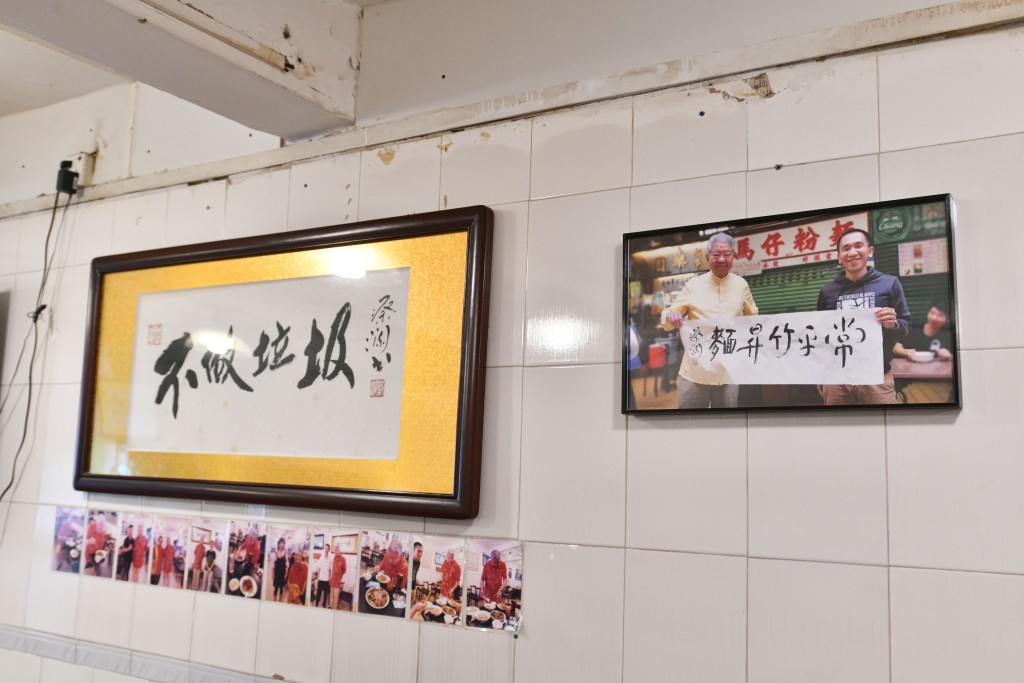 麵店牆上掛起蔡瀾和老闆的合照,以及由蔡瀾書寫的「不做垃圾」四字。 盧江球攝 麵店牆上掛起蔡瀾和老闆的合照,以及由蔡瀾書寫的「不做垃圾」四字。 盧江球攝