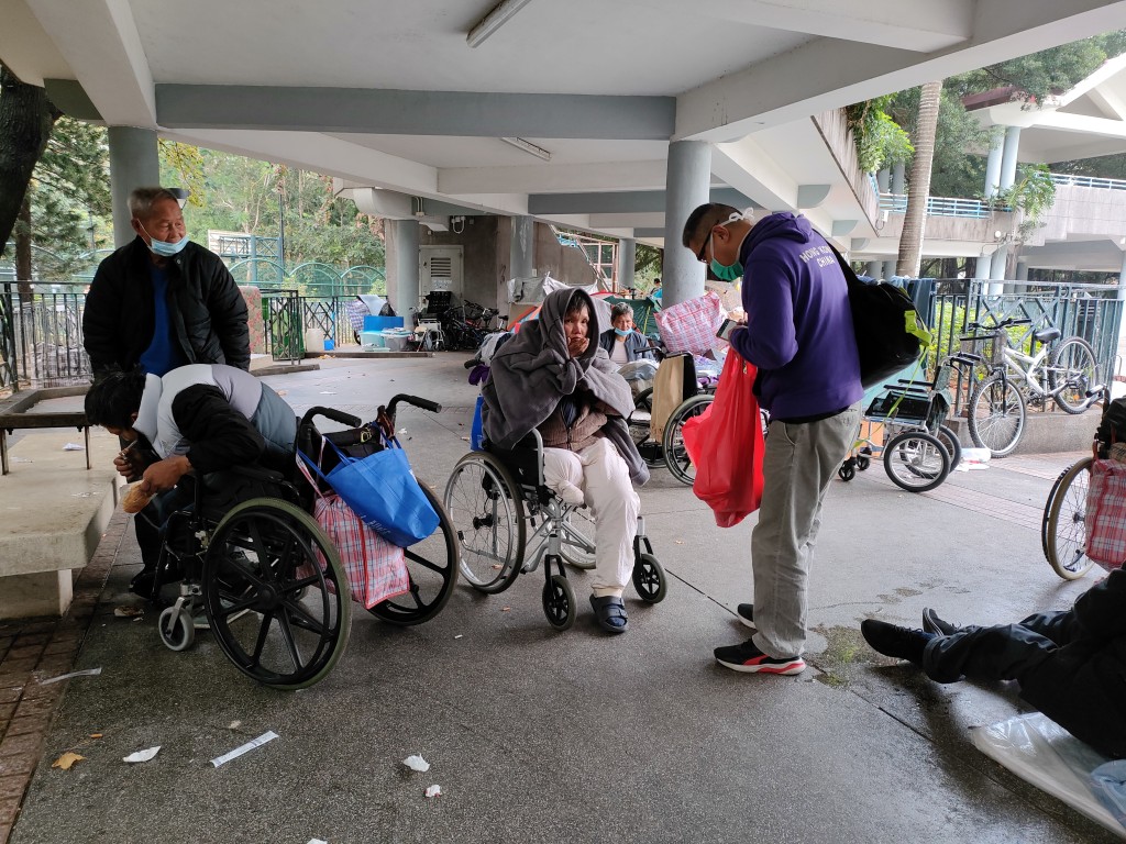 社协干事吴衞东每月定期到通州街公园派发物资。(莫家文摄)