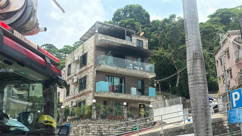 涉事村屋樓高三層，三樓單位起火由消防員救熄。