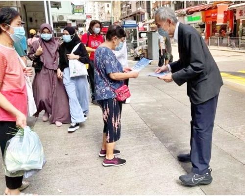 黃志祥(右)到石塘咀街市街站給市民派傳單。