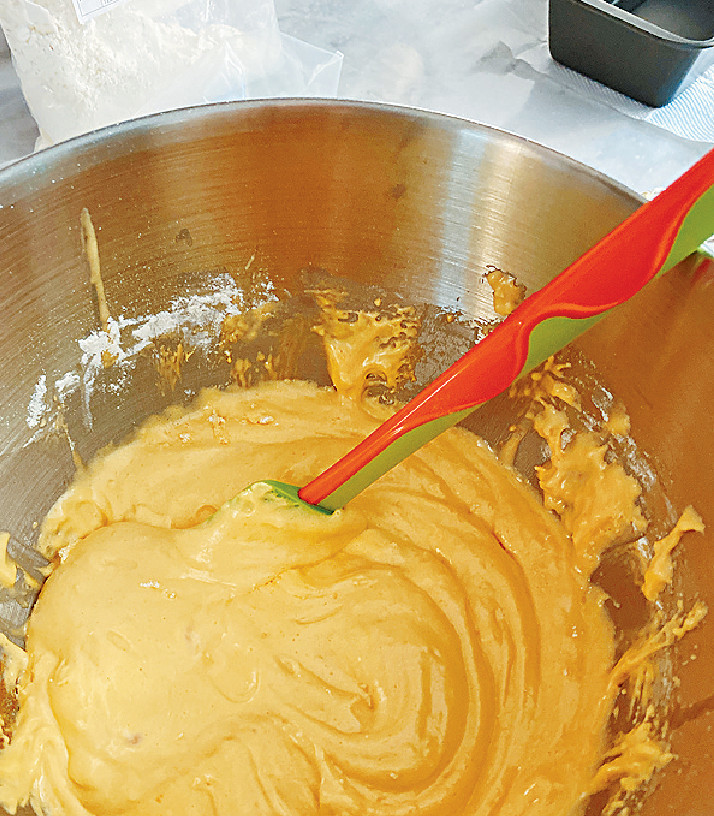 5.　再將溶化牛油（2）從盆邊注入蛋麵糊 （4），再摺入蛋麵糊。