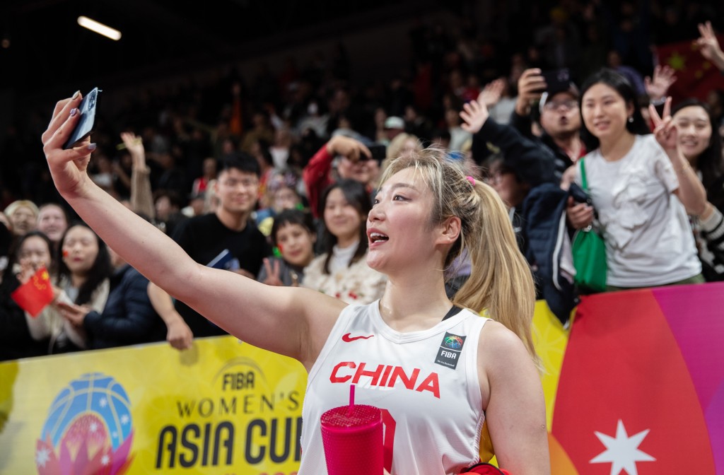 6月28日，中国队球员李梦（前）在比赛后与观众合影。当日，在澳大利亚悉尼举行的2023年女篮亚洲杯小组赛中，中国队以87比81战胜韩国队，以小组第一名的成绩晋级半决赛。（新华社）