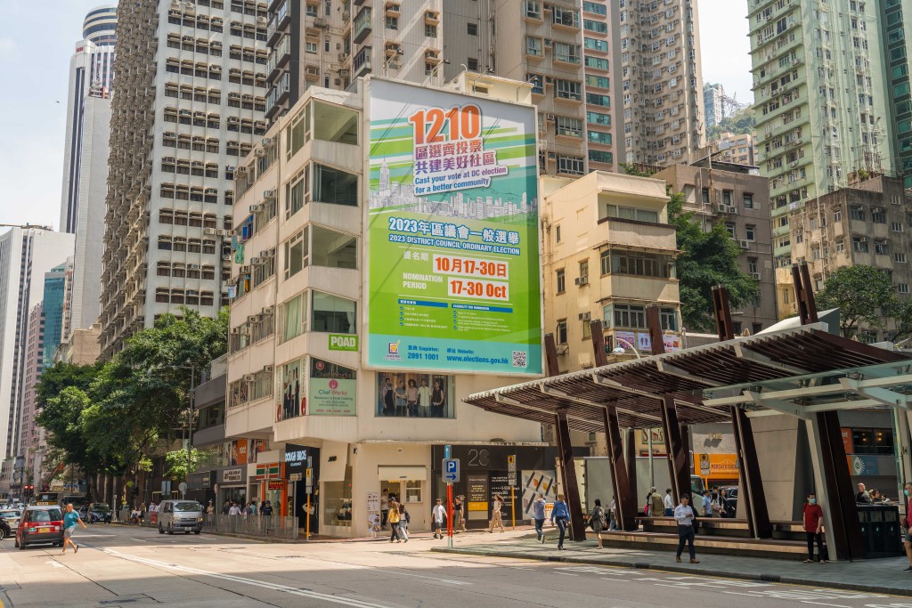 政制及內地事務局近日在全港各交通要道及建築物外牆掛起巨型海報，宣傳區議會選舉。