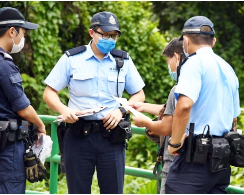 警方在行動期間,票控兩名無戴口罩的男子。