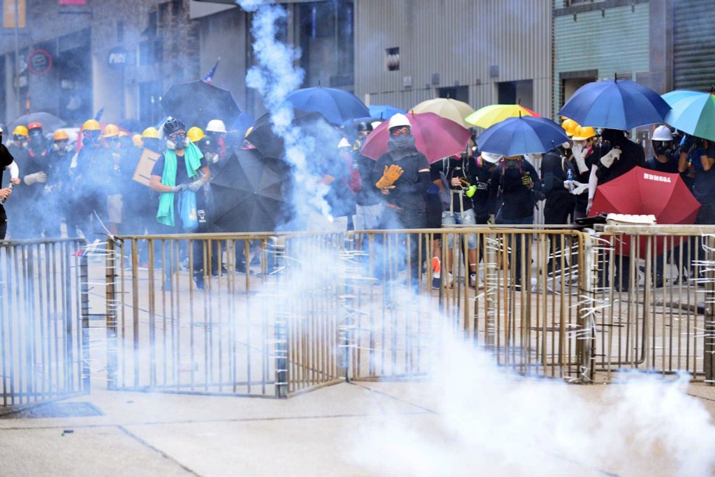 長沙灣警署警察舉黑旗後施放催淚彈。