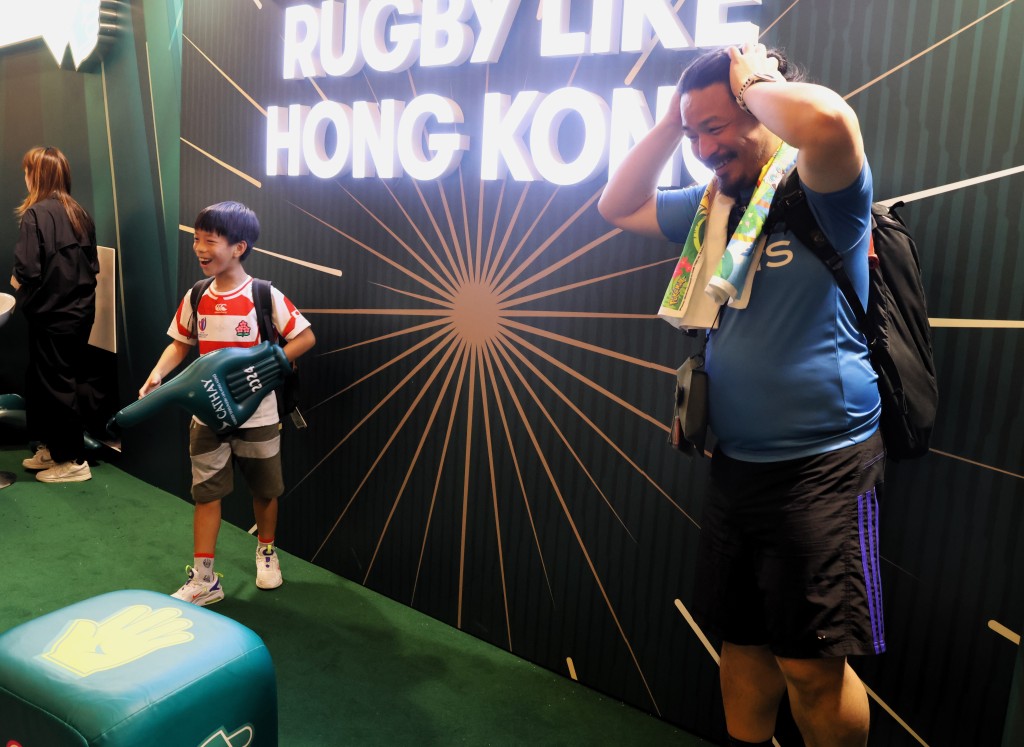 香港國際七人欖球賽周五開鑼，父子球迷玩遊戲。 陸永鴻攝