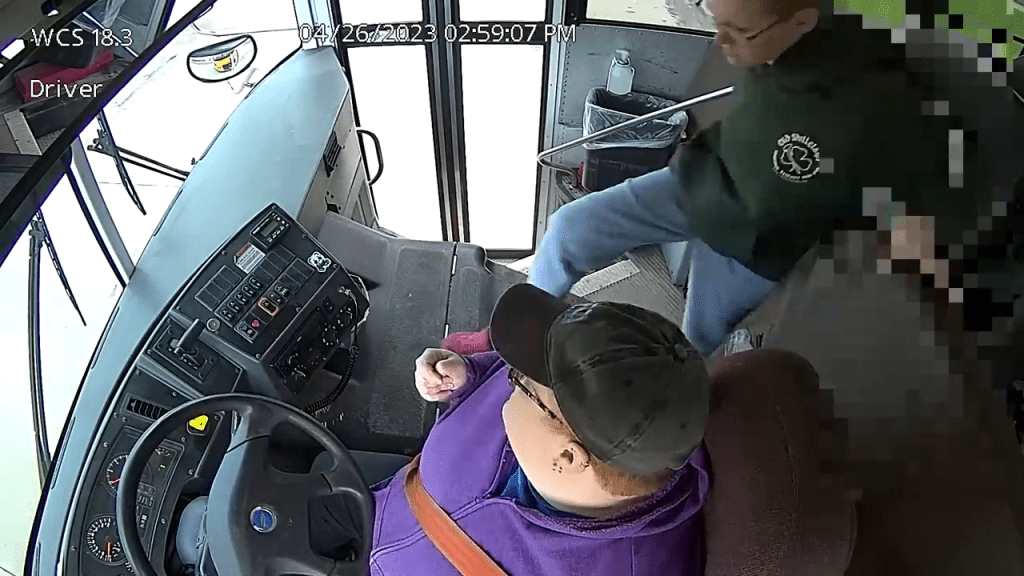 一名身穿绿色衫的男生冲向校巴司机的位置。
