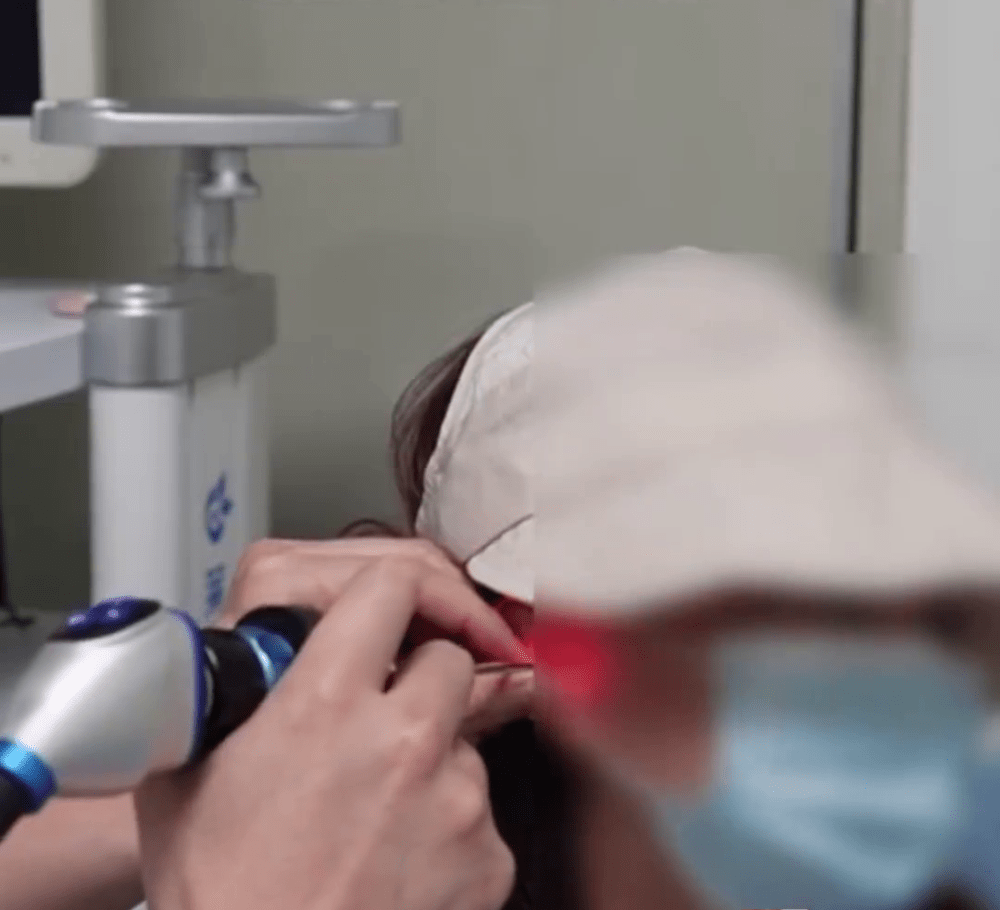 医生为女病人做耳镜。