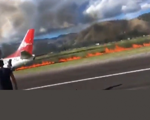 飛機在跑道外的草地留下一道長長的火道。