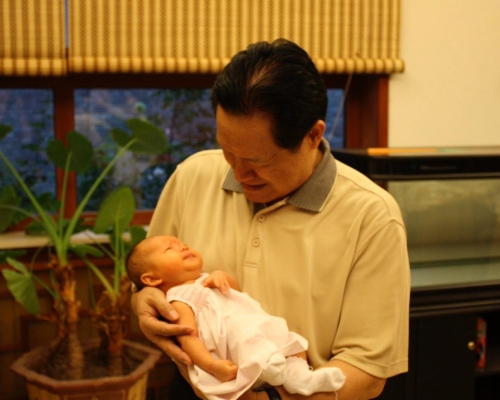 黃婉還貼出兩張周永康抱孫的照片，一臉慈祥。網上圖片