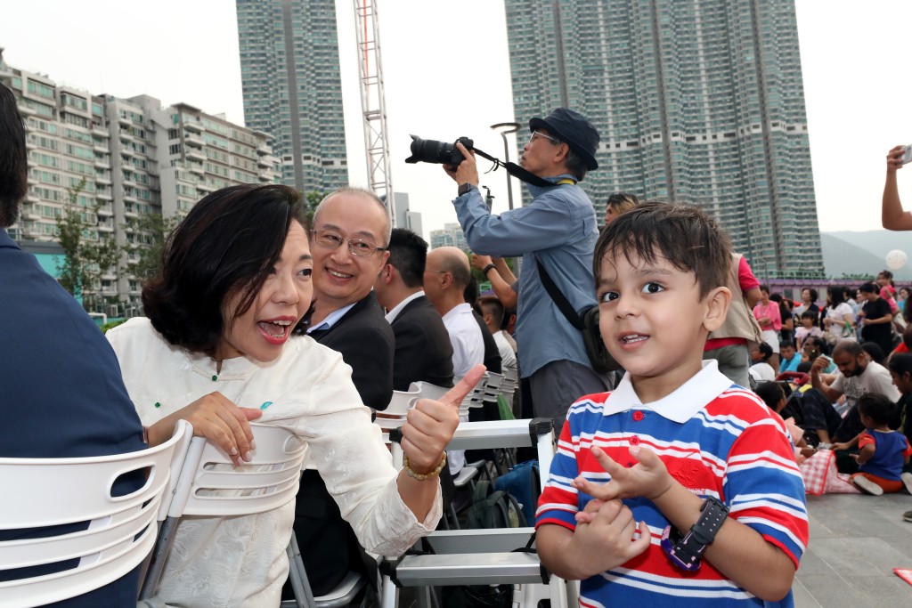 民青局局長麥美娟在國慶活動中與到場觀看表演的南亞裔男童進行互動。(方少邦攝)