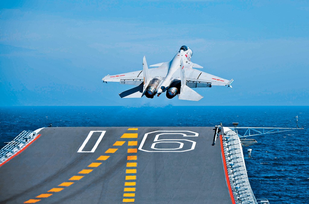 殲-15艦載戰鬥機從遼寧艦飛行甲板滑躍起飛。