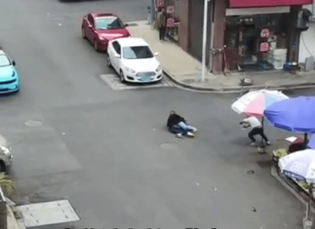 黑衫女子將拾刀的男子撲倒在地被壓在他身上。