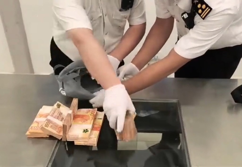 關員在男子斜孭袋內發現116萬港元現金。海關發布 關員在男子斜孭袋內發現116萬港元現金。海關發布