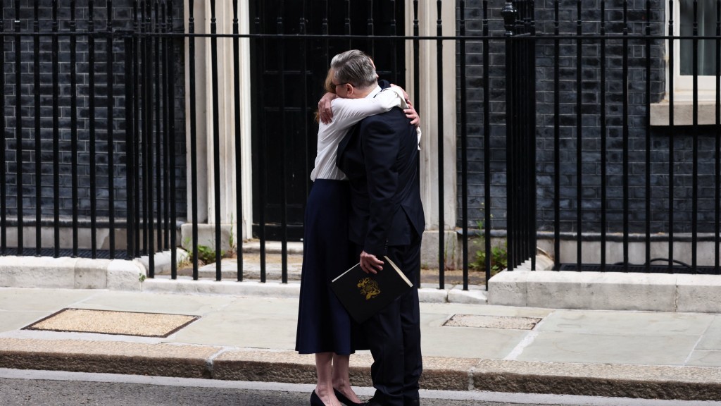 英国首相施纪贤宣布辞职，妻子拥抱给予支持。 路透社