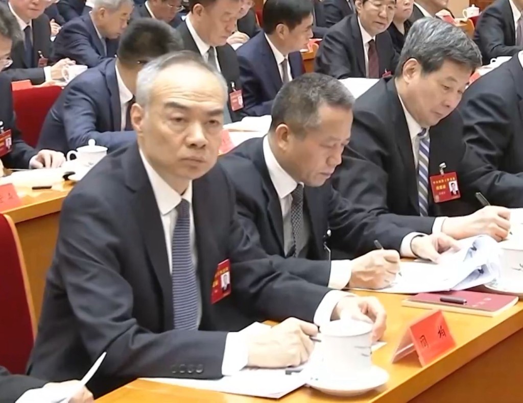 唐方裕(中)与中央政法委秘书长訚柏(左)、中央网信办主任庄荣文(右)坐在一起。央视画面 唐方裕(中)与中央政法委秘书长訚柏(左)、中央网信办主任庄荣文(右)坐在一起。央视画面