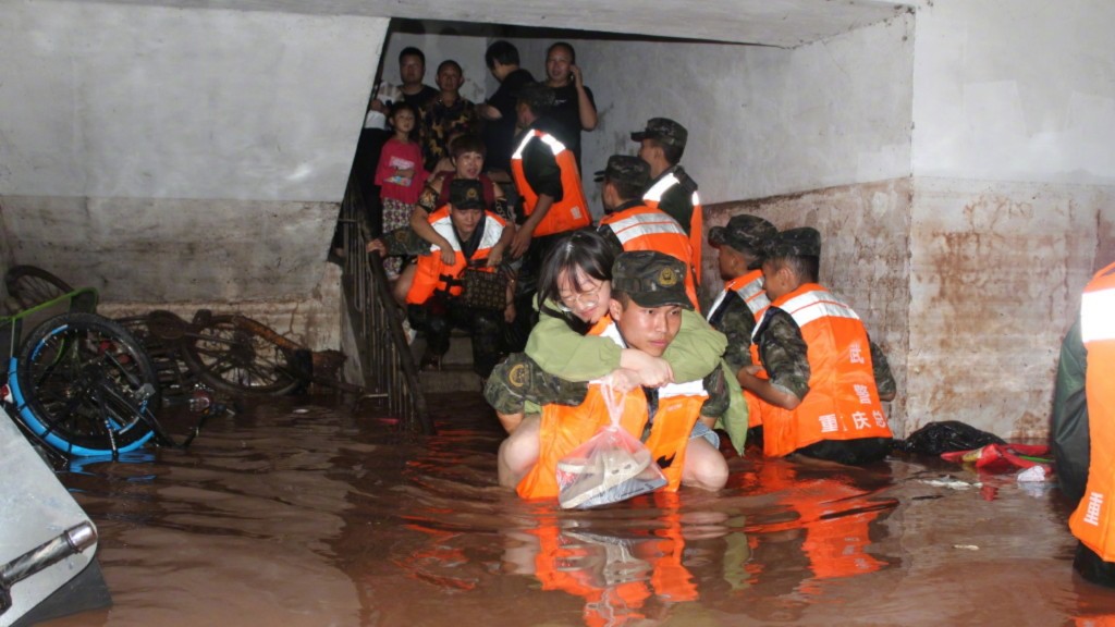 救援人員協助受災居民離開。