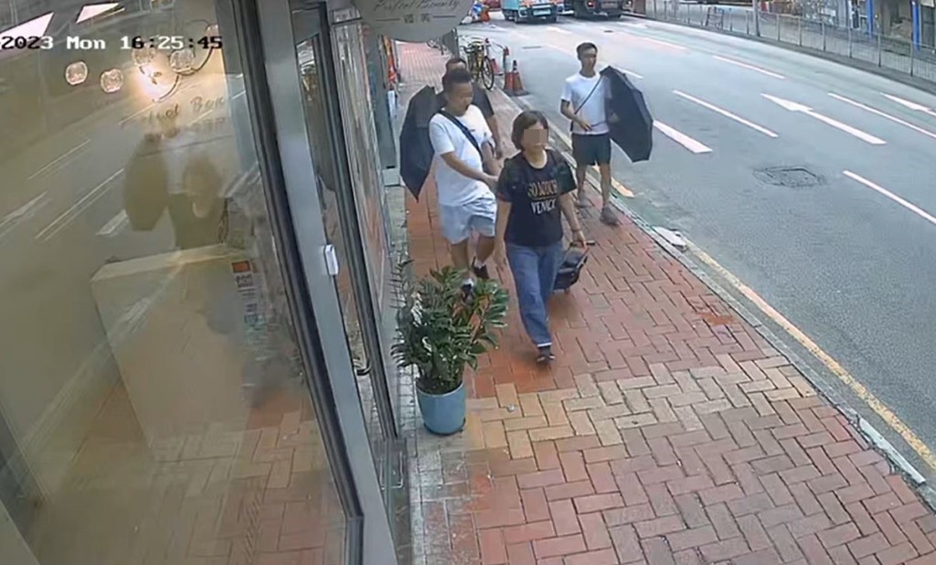贼人将手伸向女事主背囊，同党打伞在左右方掩护。fb荃湾人Rita Lai影片截图