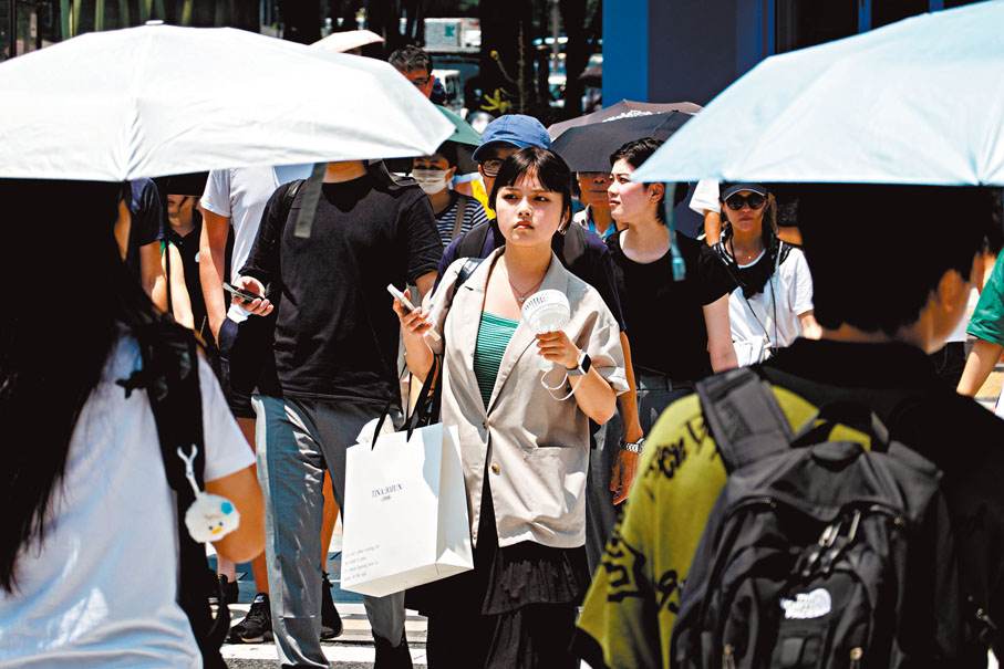 东京民众随身带备小风扇散热。新华社