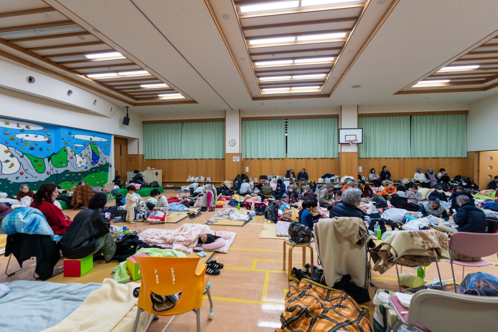 地震後人們在臨時避難所內休息。