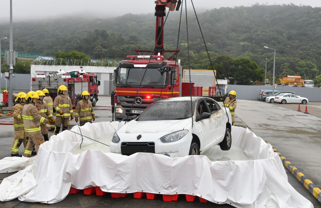  臨時水池用於浸沒已燃燒或具有復燃風險的電動車。伍明輝攝