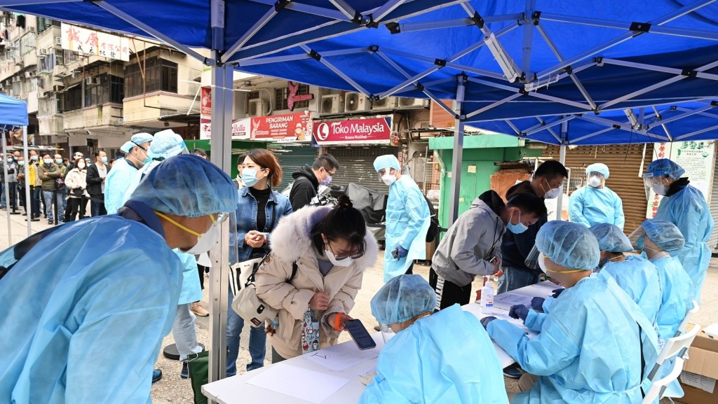 工作人員在「受限區域」內進行執法行動,檢查受限人士是否已接受強制檢測。政府新聞處