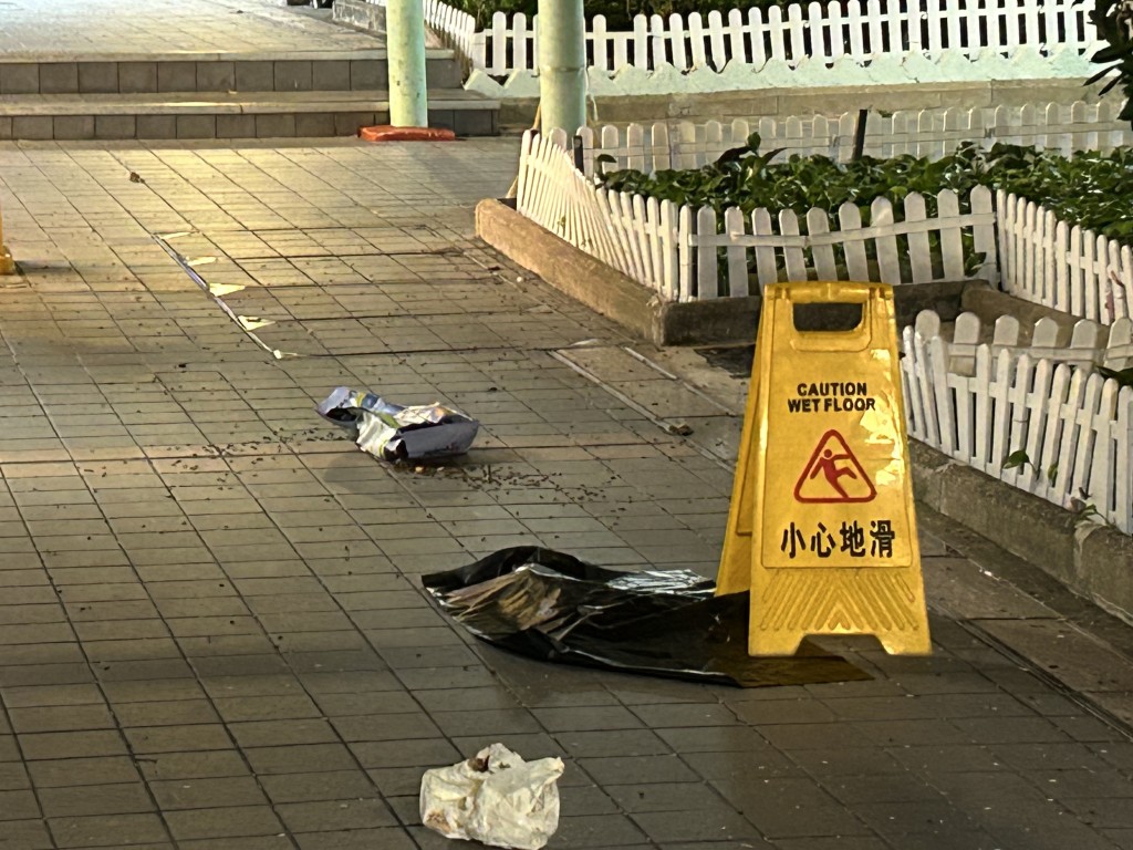 一隻幼貓伏屍行人路，旁邊有一袋已打開的貓糧。