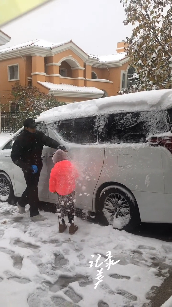 温兆伦与囡囡一同为座驾铲雪。