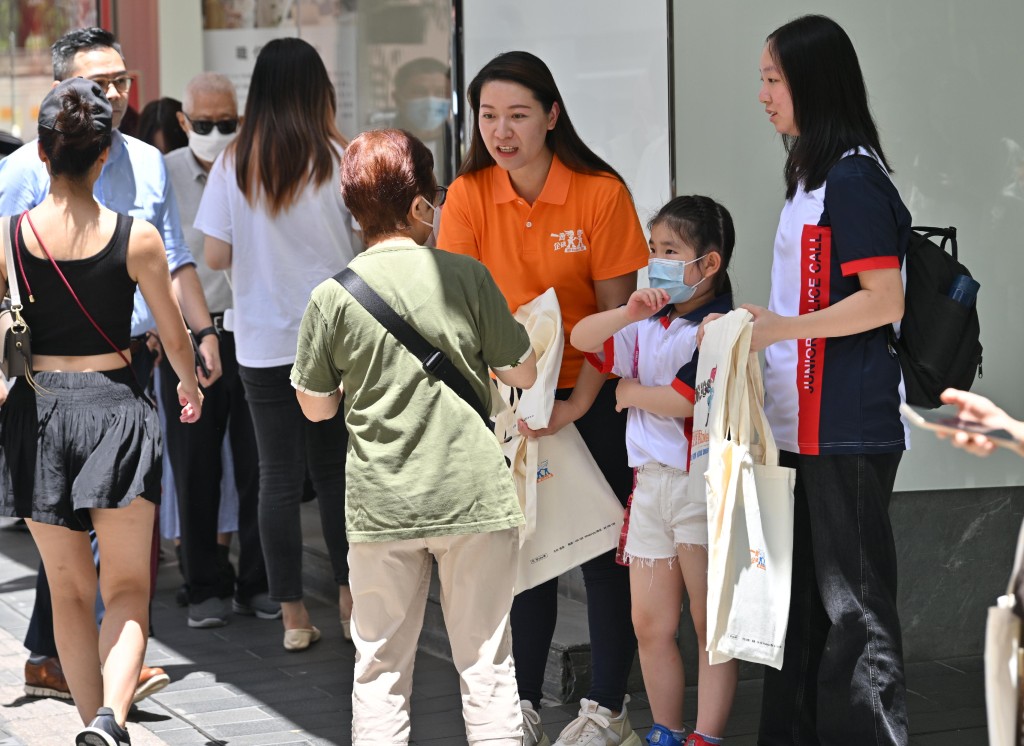 少年警讯成员（右一及右二）向市民派发禁毒单张和宣传品。政府新闻处