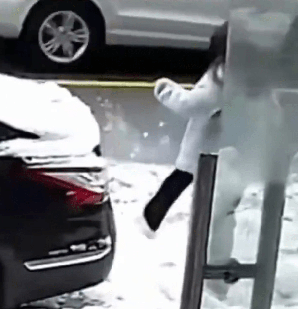 女子用脚将雪人踢散。