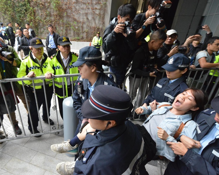 示威者被警方抬走。