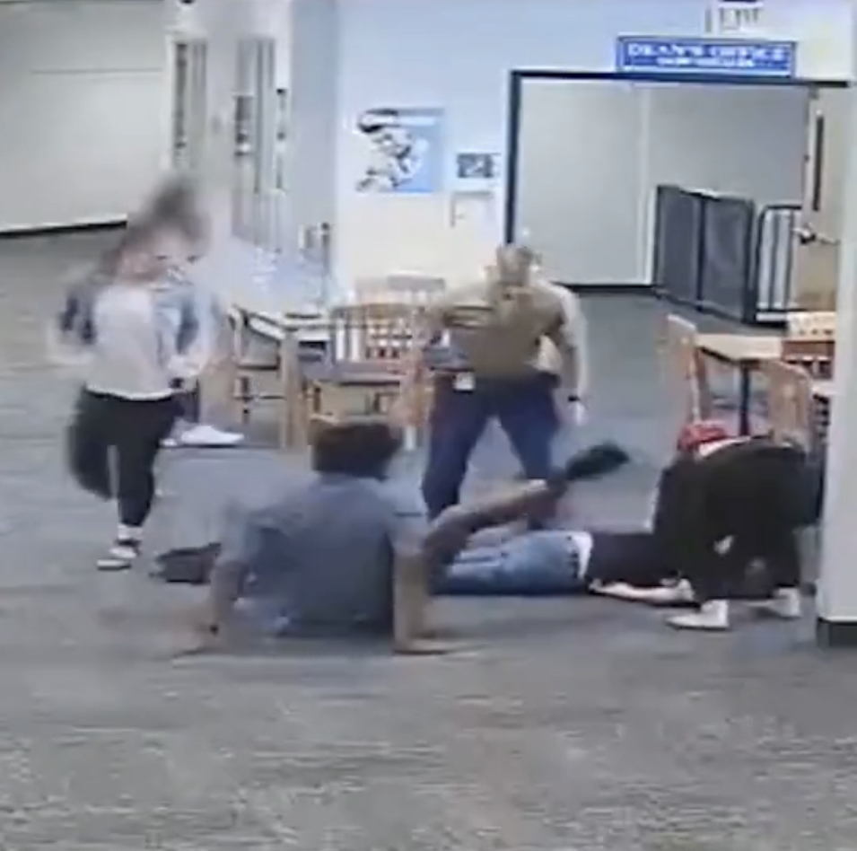 男生被推开后仍继续脚踢老师。