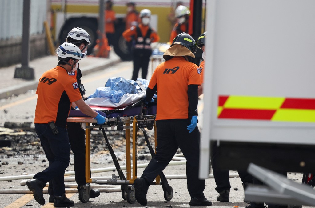 救护人员从火场抬出多名死伤者。（路透社）