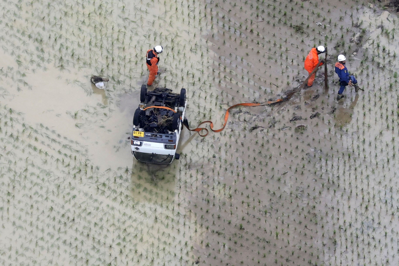 暴雨引致河流氾濫,汽車被沖到稻田。AP