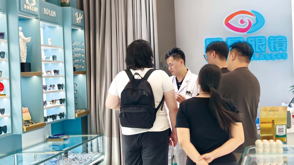 店員顥哥在幫顧客挑選眼鏡。