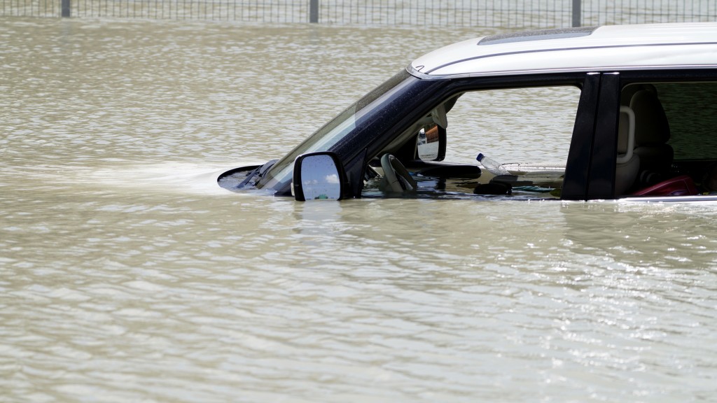 杜拜罕見暴雨，一輛休旅車被棄置在路中心，連車內也濕透。 美聯社