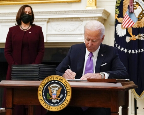 美國總統拜登（右）簽署多項行政命令，全面應對美國新冠肺炎疫情。AP圖片