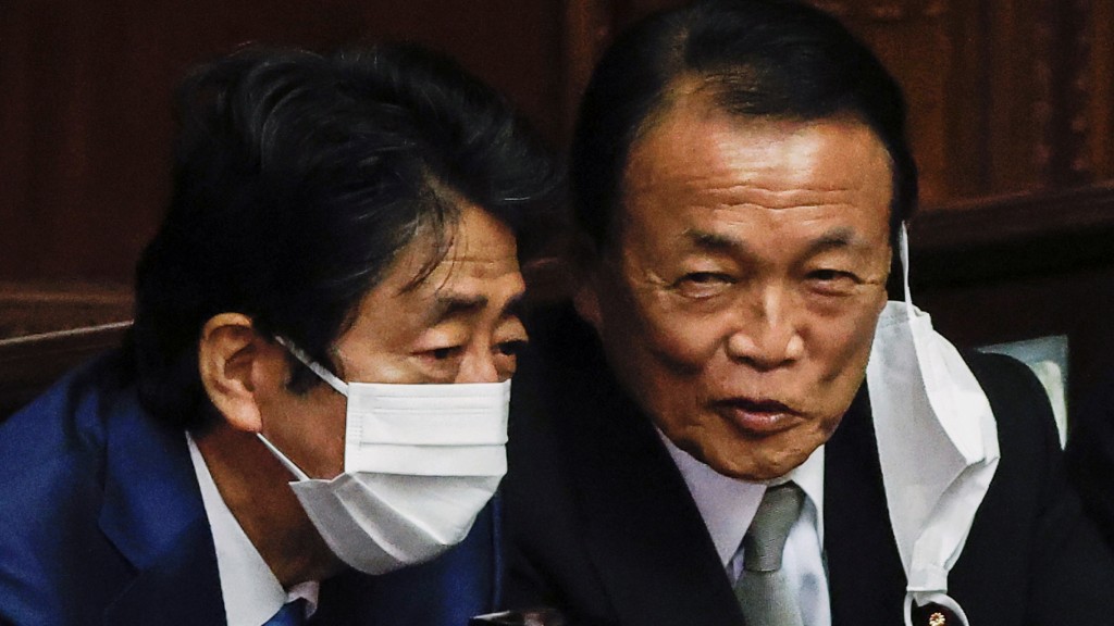 麻生太郎与已故前首相安倍晋三（左）。 路透社